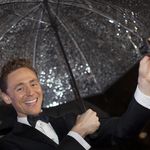 Том Хидълстън под чадър