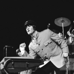 Джон Ленън свири с лакът, 1965 г.