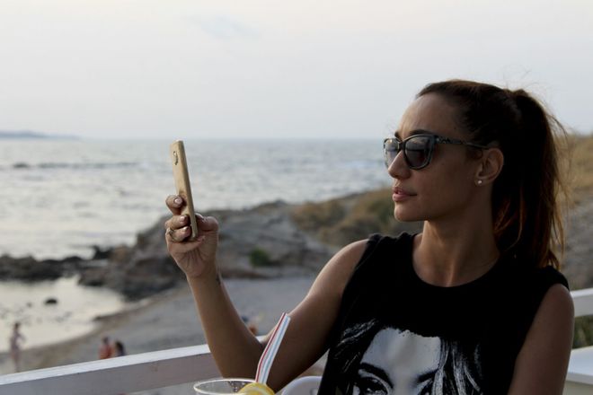 Мария Илиева край морето със смартфона си