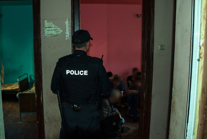 Полицай охранява задържани нелегални имигранти