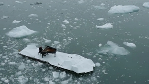 Музикант свири на пиано, заобиколен от айсберги