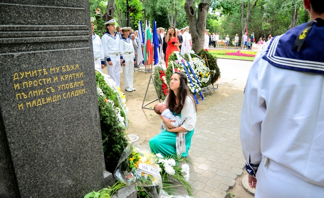 Майка коленичи с бебето си пред паметника на Левски